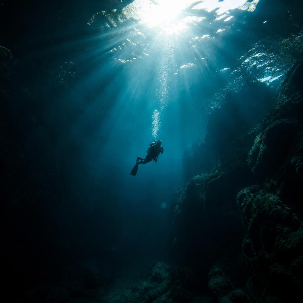Underwater film still of a diver in sunbeams